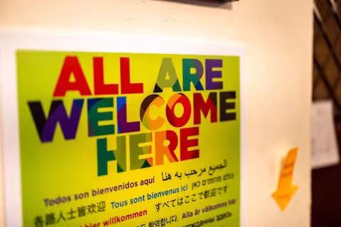 A sign on the wall at RISSE reads "All are welcome here"