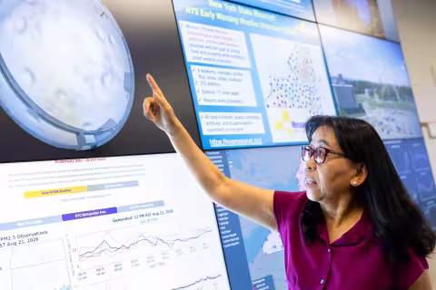 June Wang points to a birds eye camera view of a New York State Mesonet site.