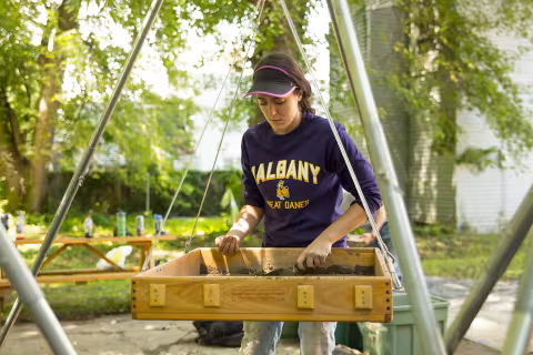 A UAlbany anthropology student working on an archaeological dig site.