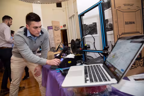 A student giving a 3D printer demonstration.