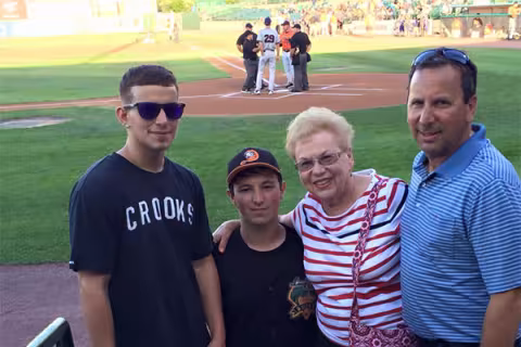 Luc as bat boy for the Long Island ducks with his family on the field