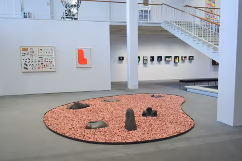 a rock garden shaped like an pallette mixer with art work in the background