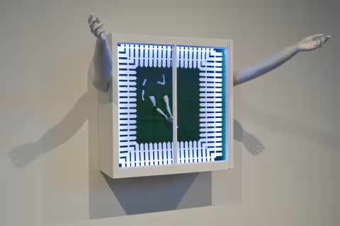 a box with illuminated fence and plastic limbs on green, with two arms on the side