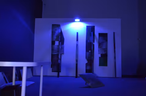 a room with a blacklight and irregular art displayed on the floor and wall