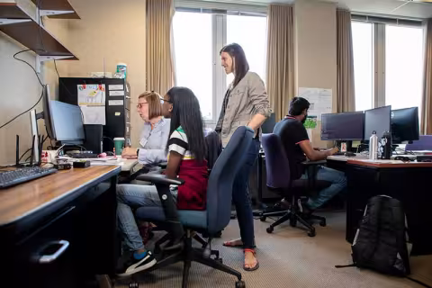 students with a professor in a computer lab