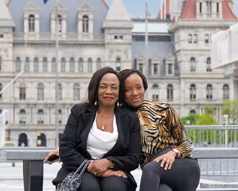 Michelle and her mom take a picture in downtown Albany at the capital.