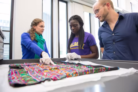 Anthropology graduate students work with an undergraduate student inside the Arts and Sciences Building.
