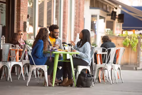Three students eat at a restaurant in downtown Albany.