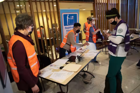 Volunteers staffing a table at the vaccine POD on campus