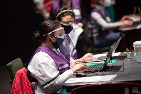 Volunteers working on computers at the POD vaccine site on-campus.