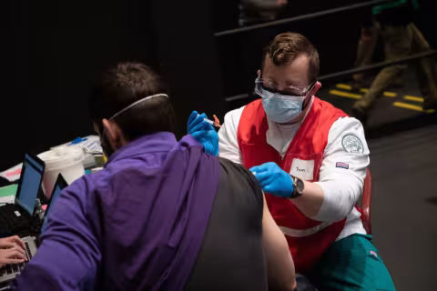A volunteer giving a vaccination.