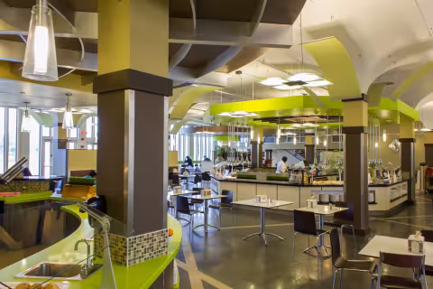 State Quad Dining Hall, with green walls, food stations, tables and chairs