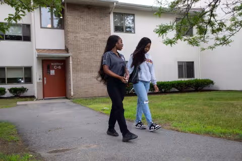 Two students walk down a path outside Freedom Apartments' C6.