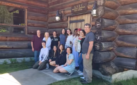Students and faculty members who participated in the Common Ground in the Clouds Program pose in two rows for a photo in front of the Atmospheric Sciences Research Center's Whiteface Mountain Field Station.