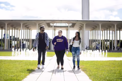 Three students walking together on campus.
