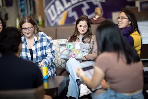 A group of students study together in a circle at the campus center
