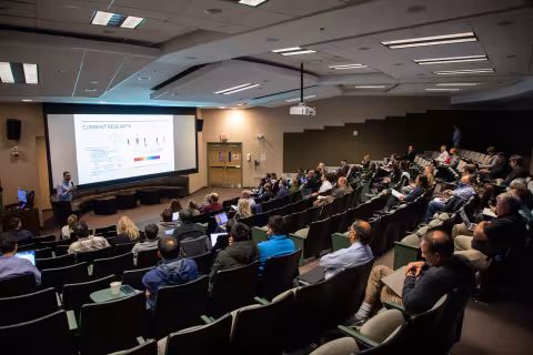 A group of people watching a presentation.