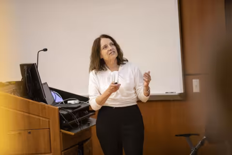 Sally temple delivers her keynote talk standing at a podium. 
