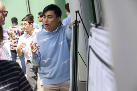A student presents his research poster. 