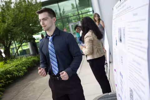 A student presents his research poster.