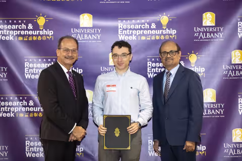 Jeremy Feldblyum, Chemistry, with UAlbany President Havidán Rodríguez and Vice President for Research and Economic Development Thenkurussi “Kesh” Kesavadas.