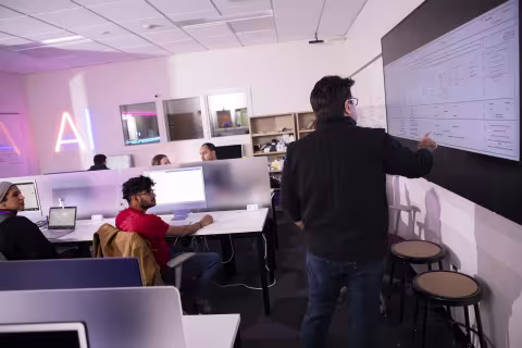M. Abdullah Canbaz speaks with students inside CEHC's AI in Complex Systems Laboratory.