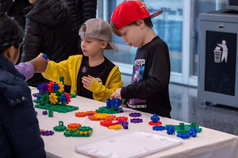 Two young boys enjoy a table-top experiment at UAlbany's STEM & Nanotechnology Family Day at ETEC.