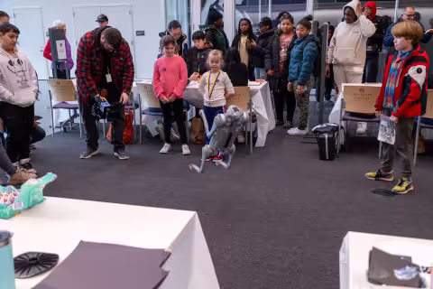 A group of students watch a robotic dog flip and do tricks UAlbany's STEM & Nanotechnology Family Day at ETEC.