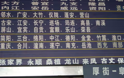 A black sign with white Chinese lettering displaying different destinations in China