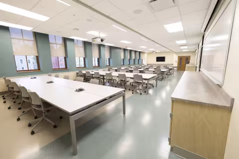 A long classroom space with many parallel benches of computer desks