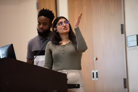 Two students showcase their work on a screen during Showcase Day 2024.