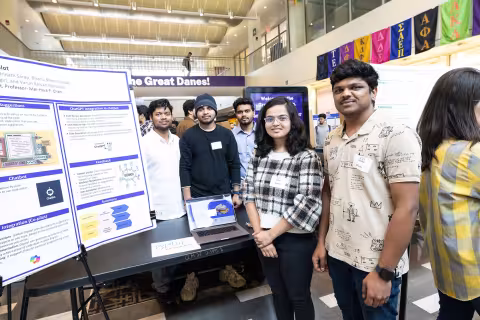 A pair of students stands next to their poster during Showcase Day 2024.