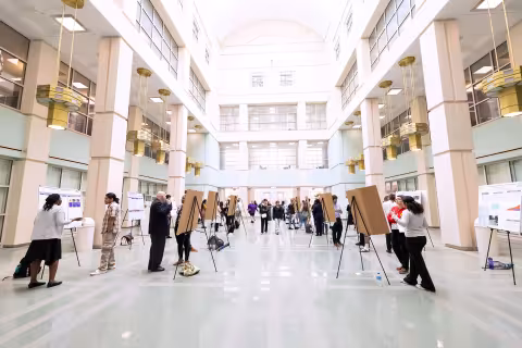 The Science Library Atrium is filled with posters, guests and students during Showcase Day 2024.