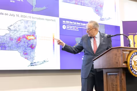 Senator Schumer points to a Mesonet map during a press conference at ETEC.
