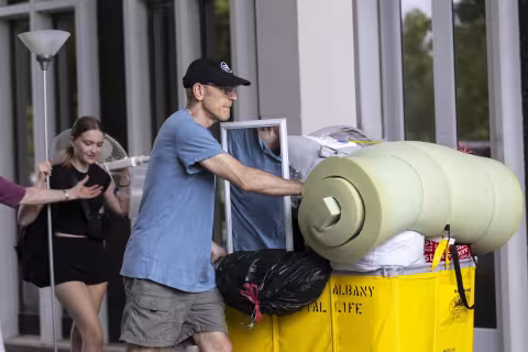 A UAlbany Dad wheels his daughters' dorm items on move-in day.