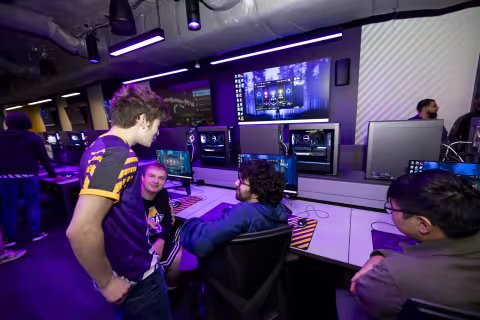 UAlbany students stand around a gaming PC in the new esports arena.