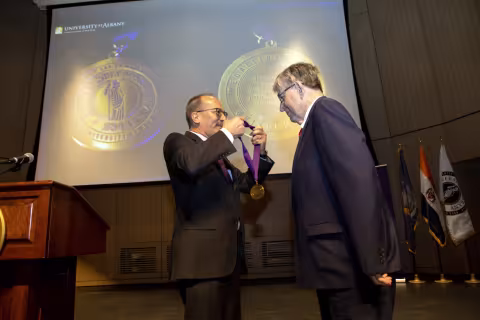 President awarding New York State Senator Neil Breslin the Medallion of the University.