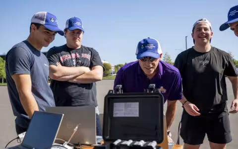 ASRC's Jeff Freedman (middle) reviews weather balloon data in real time with students following a practice launch from the ETEC parking lot. (Photo by Brian Busher)