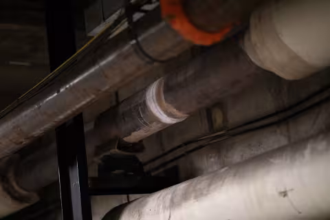 A photo of a metallic gray pipe with a a white ring showing a recent weld.