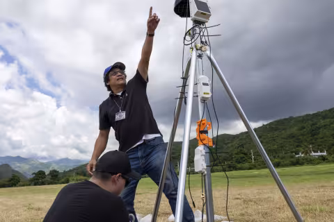 Empire Innovation Professor Jorge González-Cruz points at the sky behind research instrumentation.