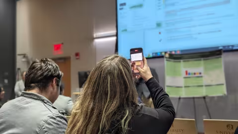 A participant snaps a picture of the presentation slide during a keynote speech.