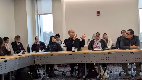 Conference participants from multiple universities engaging in discussion.