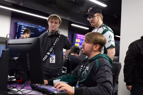 Students gather around a gaming PC during the SUNY Esports Tournament.