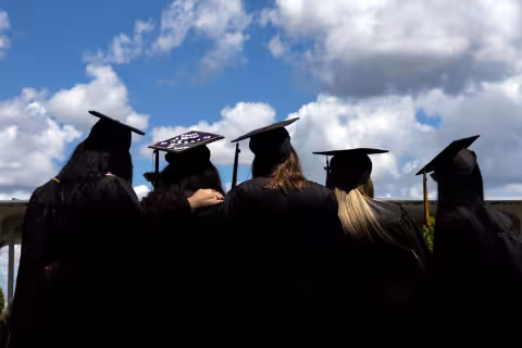 Students looking up at the sky in their caps and gowns