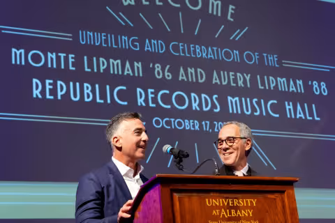 Lipman brothers stand at podium to announce the unveiling of the Monte Lipman '86 and Avery Lipman '88 Republic Records Music Hall