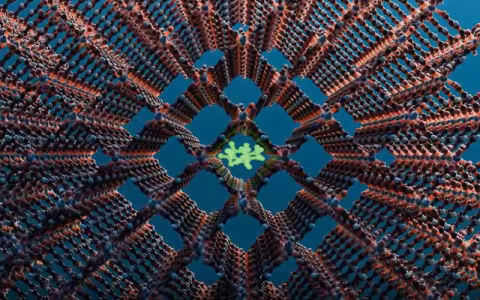 Computer rendering of a metal-organic framework. The image features a lattice of brown rods and blue nodes, arranged in a 3D crosshair pattern. In the center is a shape made of green rods and green nodes in a cluster, trapped in a central square.  