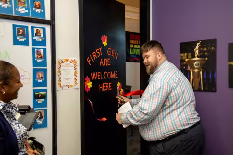 A man cuts a red ribbon to a lounge for First-Gen students