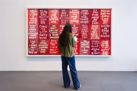 Student standing in front of a large framed print