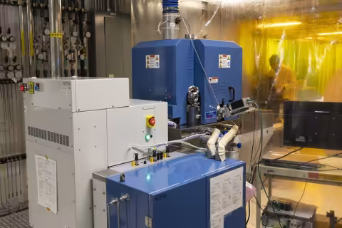 A photo of a gray and blue piece of laboratory equipment the size and shape of several washing machines.