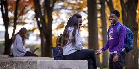 Students talking and laughing together outside on one of the quads.